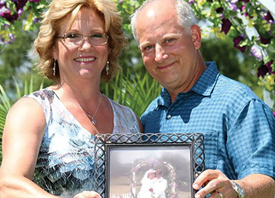 Dave and Laura (Sinning) Knoll pose with their wedding photo from 1984.