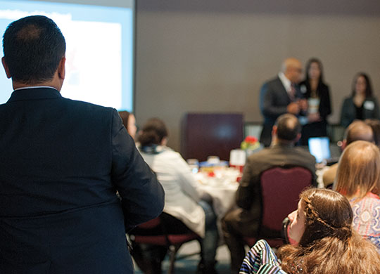 LBEDC Director Carlos Sanchez (left) looks on during a Latino Talent Initiative award ceremony on April 8, 2016.
