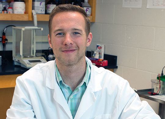 2017 Student Research Fellowship student participant Hunter Pope posing in a biology lab.